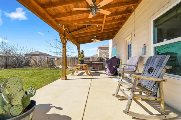 a view of a backyard with table and chairs potted plants with wooden floor