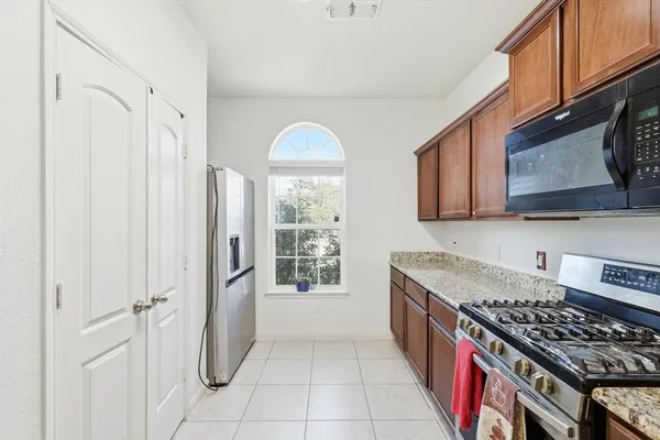 a kitchen with stainless steel appliances granite countertop a stove a sink and a microwave