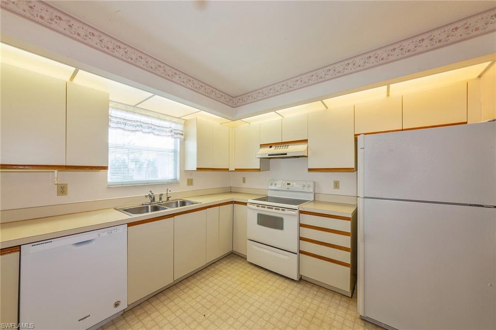 1535 Trafalgar Lane, Unit R201 Naples, FL 34116 - Photo 3 of 10 a kitchen with appliances a sink and cabinets