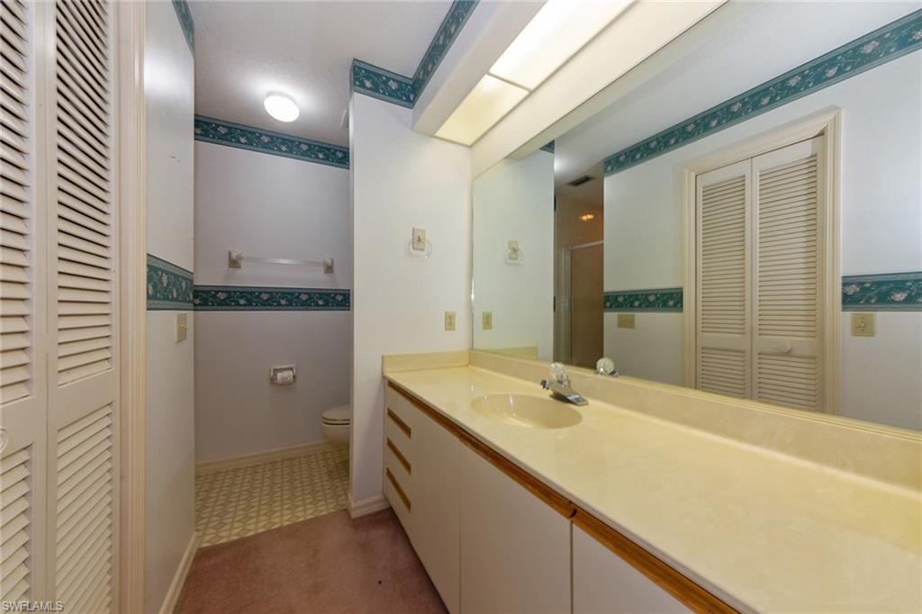 1535 Trafalgar Lane, Unit R201 Naples, FL 34116 - Photo 6 of 10 a bathroom with a granite countertop sink and a mirror