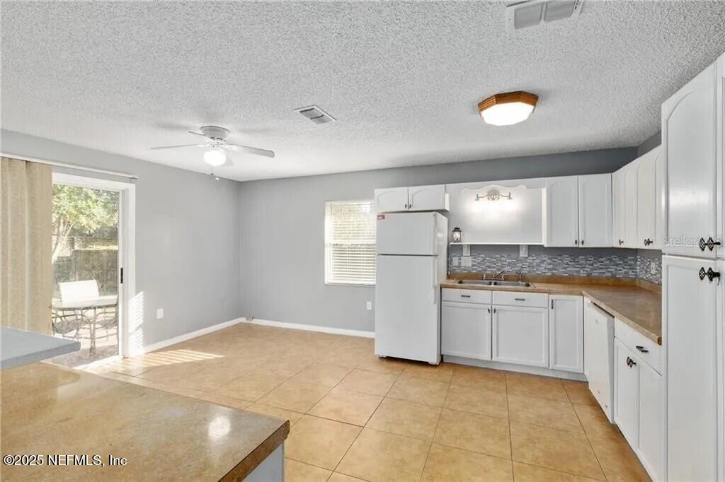 3991 Southeast 19th Avenue Ocala, FL 34480 - Photo 4 of 11 a kitchen with granite countertop a sink a stove a refrigerator and white cabinets