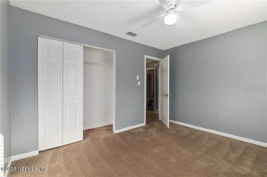 3991 Southeast 19th Avenue Ocala, FL 34480 - Photo 8 of 11 an empty room with closet and a chandelier fan