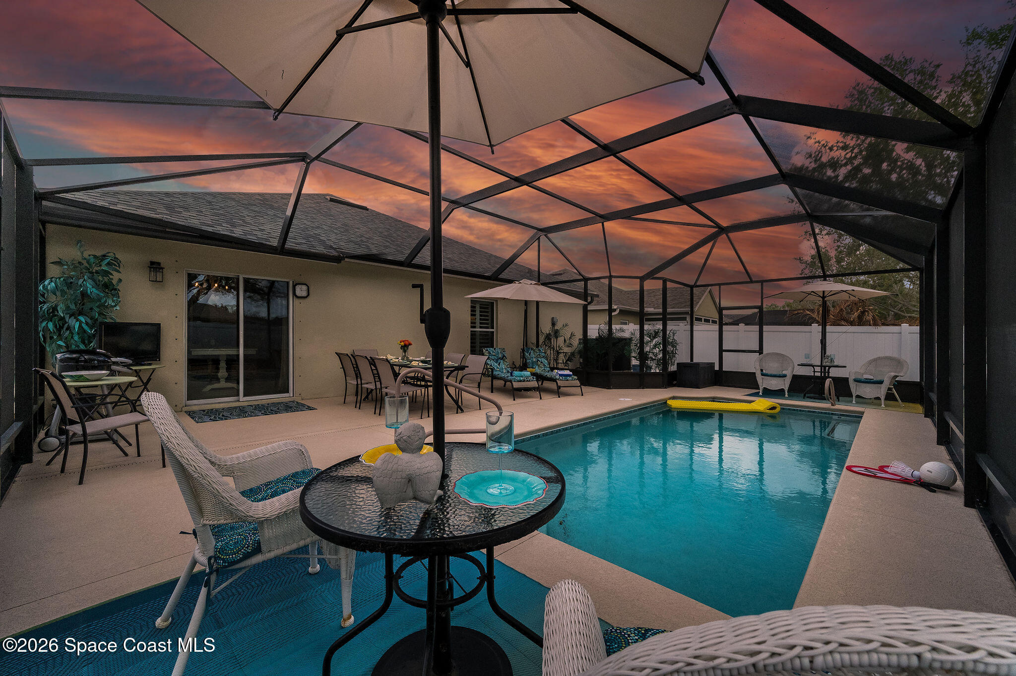 3911 Joslin Way Melbourne, FL 32904 - Photo 1 of 63 a view of a swimming pool with a table and chairs under an umbrella