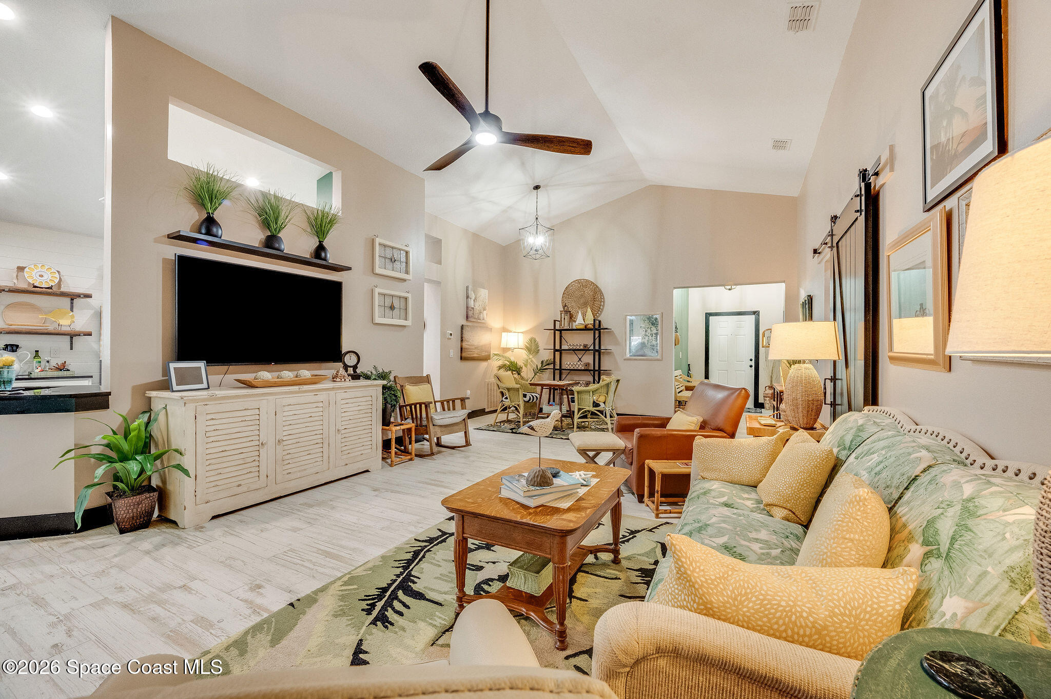 3911 Joslin Way Melbourne, FL 32904 - Photo 15 of 63 a living room with furniture a flat screen tv and a chandelier