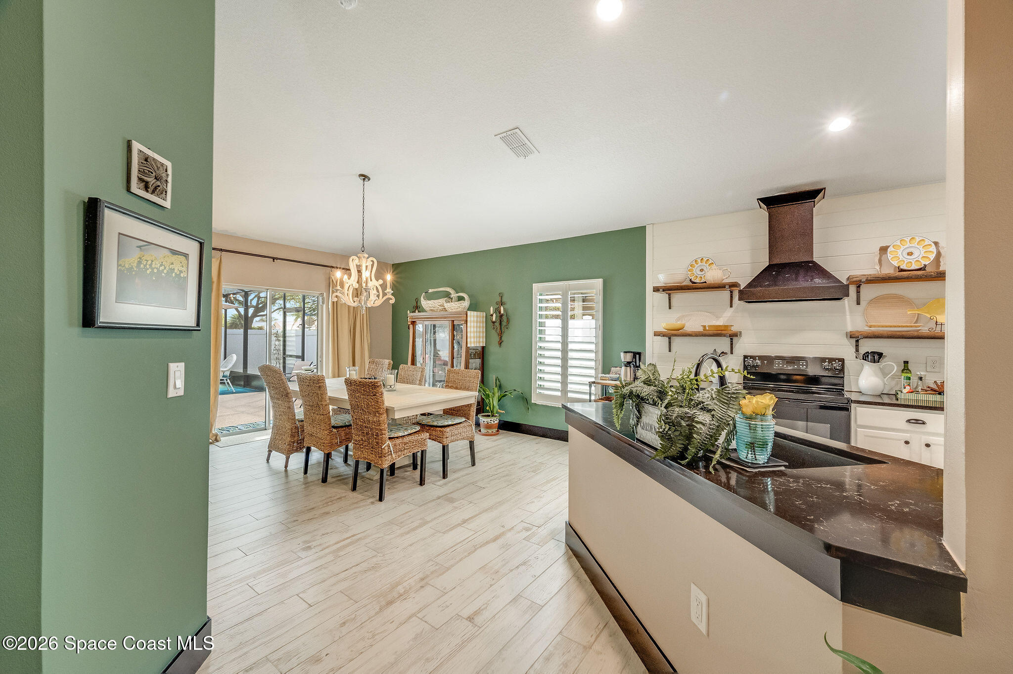 3911 Joslin Way Melbourne, FL 32904 - Photo 16 of 63 a view of a dining room and livingroom with furniture wooden floor a chandelier