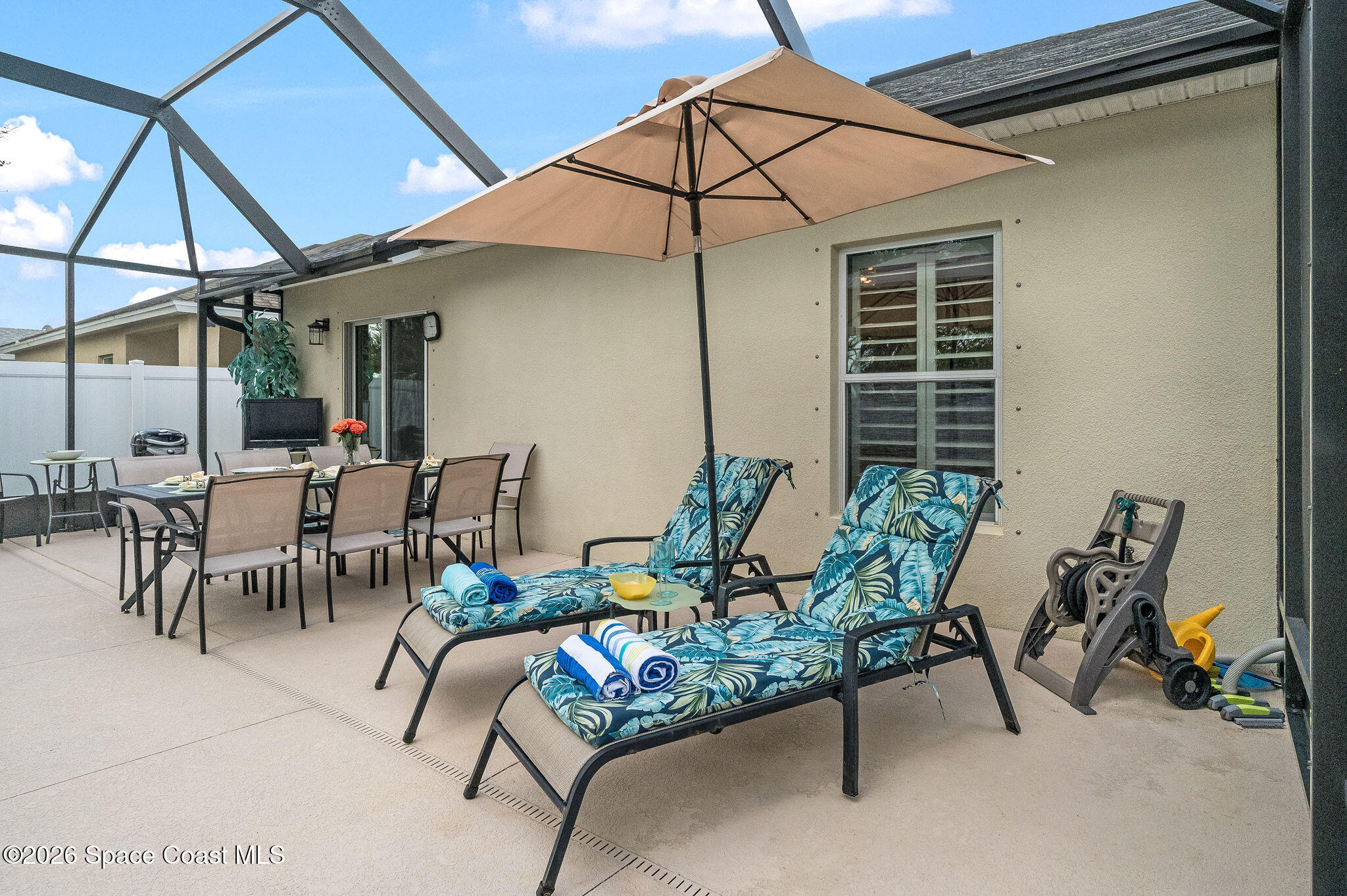 3911 Joslin Way Melbourne, FL 32904 - Photo 46 of 63 a view of a patio with a table and chairs under an umbrella