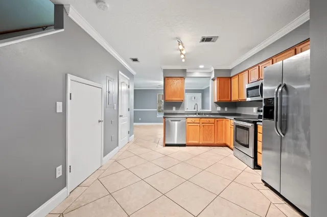 a kitchen with stainless steel appliances kitchen island granite countertop a refrigerator and a stove top oven