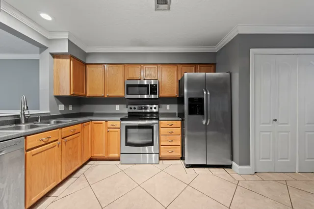 a kitchen with stainless steel appliances granite countertop a refrigerator and a sink