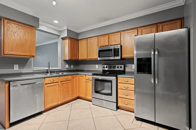 a kitchen with stainless steel appliances granite countertop a refrigerator sink and stove