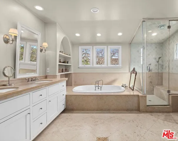 a spacious bathroom with a double vanity sink a mirror and a bathtub
