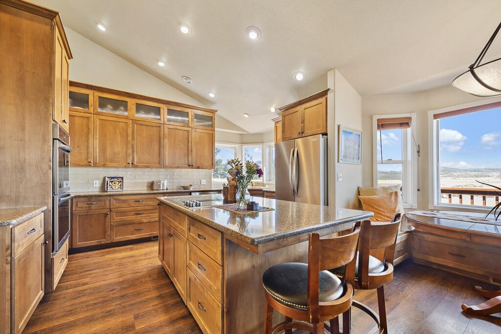 13351 Crystal Springs Road Klamath Falls, OR 97603 - Photo 22 of 51 a kitchen with stainless steel appliances granite countertop sink stove refrigerator dining table and chairs