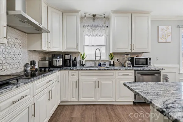 a kitchen with granite countertop white cabinets and white appliances