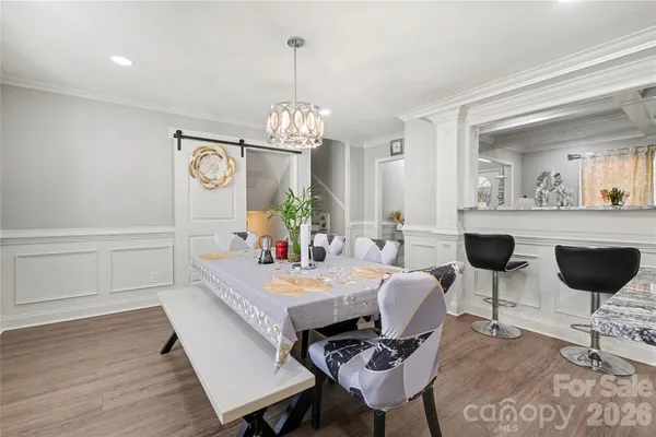 a view of a dining room with furniture a chandelier and wooden floor