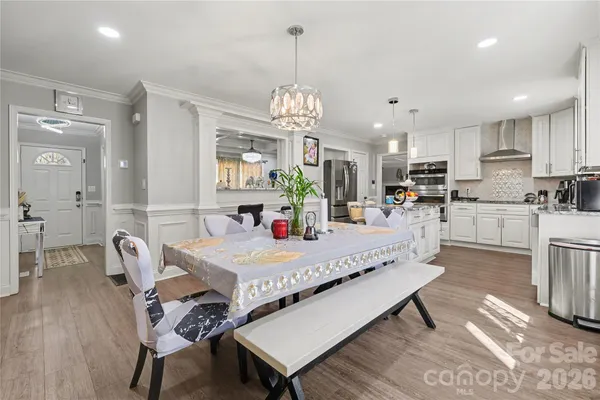 a large white kitchen with a dining table chairs and couches