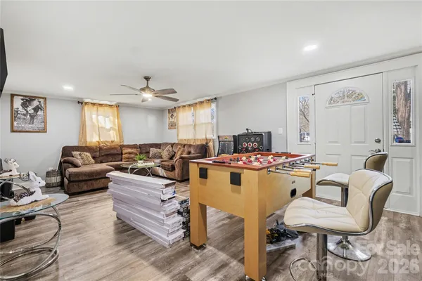 a living room with furniture kitchen view and a window