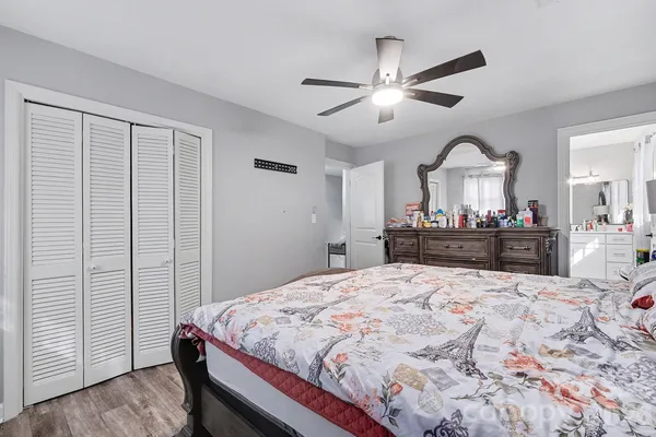 a spacious bedroom with a large bed and a chandelier