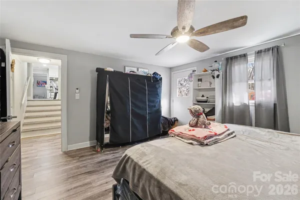 a bedroom with a bed a chandelier and a flat tv screen