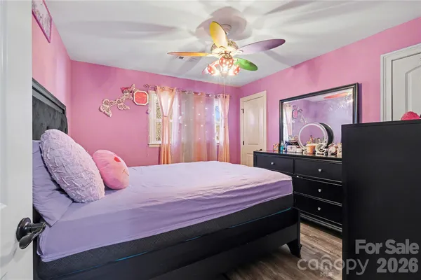 a bedroom with a bed dresser and a chandelier