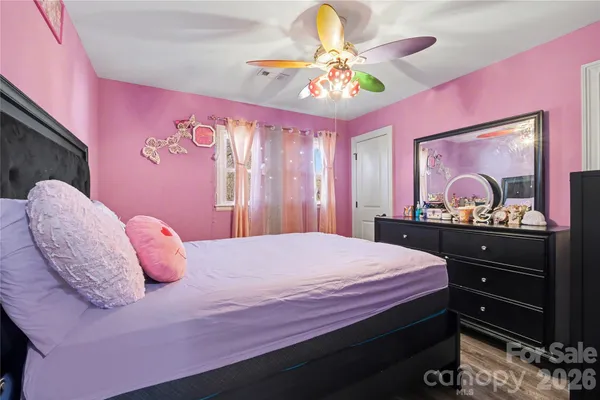 a bedroom with a bed and a mirror on dresser