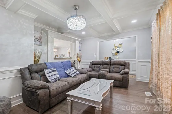 a living room with furniture and a chandelier
