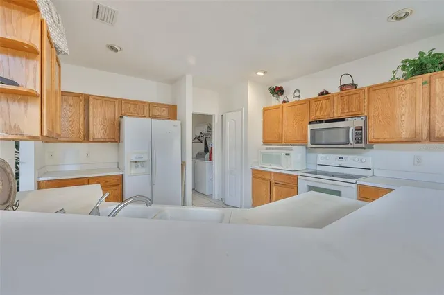 a kitchen with stainless steel appliances granite countertop a refrigerator and a stove top oven
