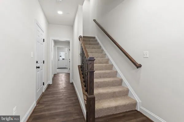 a view of a hallway with wooden floor and entryway