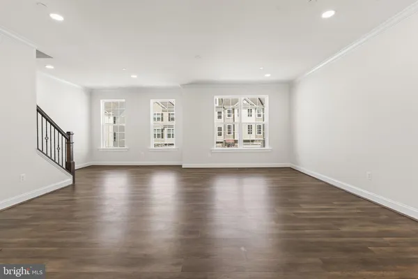 a kitchen with stainless steel appliances a stove a sink dishwasher a refrigerator and a microwave oven with wooden floor