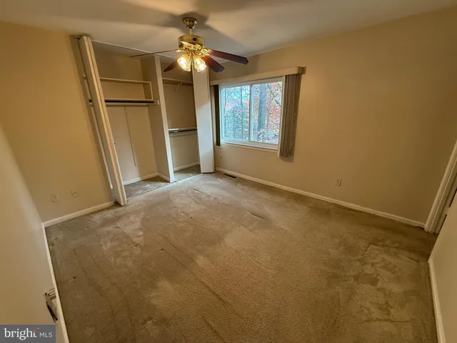 an empty room with windows and refrigerator