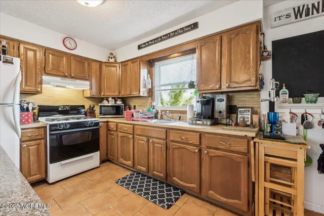 a kitchen with stainless steel appliances a stove a sink and a microwave