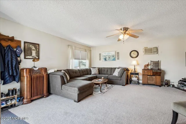 a living room with furniture a flat screen tv and a window