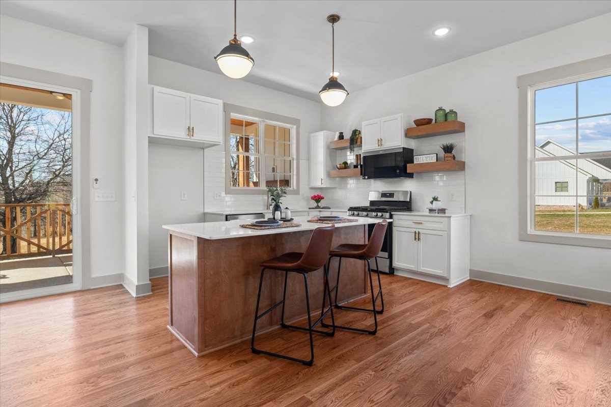 795 Jason Chapel Road Dickson, TN 37055 - Photo 13 of 35 a kitchen with stainless steel appliances granite countertop a refrigerator a sink dishwasher a stove and white countertops with wooden floor