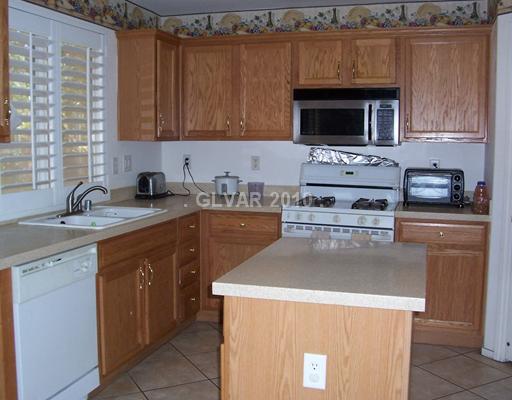 4765 Arial Ridge Street Las Vegas, NV 89147 - Photo 8 of 25 Kitchen. COZY KITCHEN WITH CUTE ISLAND COUNTER, GRANITE COUNTERTOPS, CUSTOM CABINETS & PANTRY