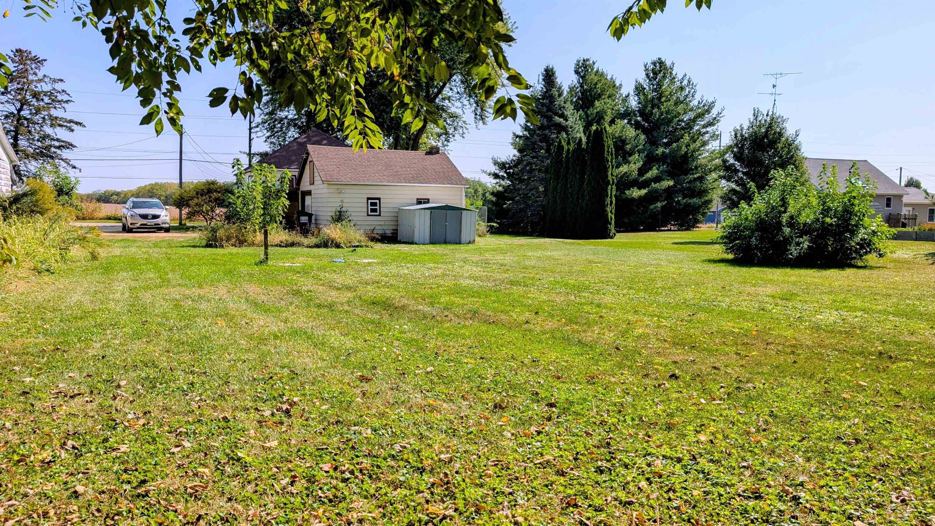 2156 North Leaf River Road Mount Morris, IL 61054 - Photo 20 of 21 a yellow house with trees in front of it