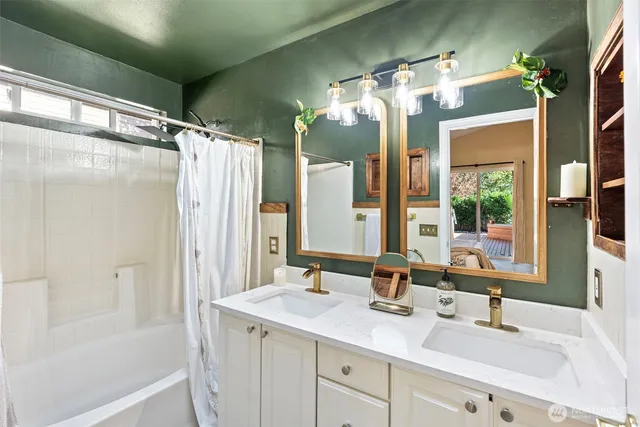 a bathroom with a double vanity sink mirror and shower