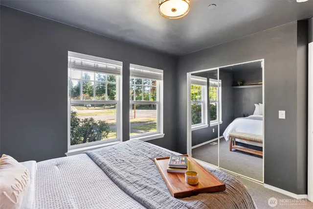 a bedroom with a bed and a large window