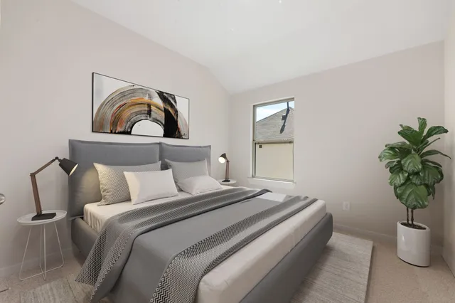 a bedroom with a bed and a potted plant