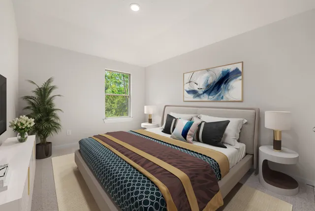 a bedroom with a large bed and a potted plant