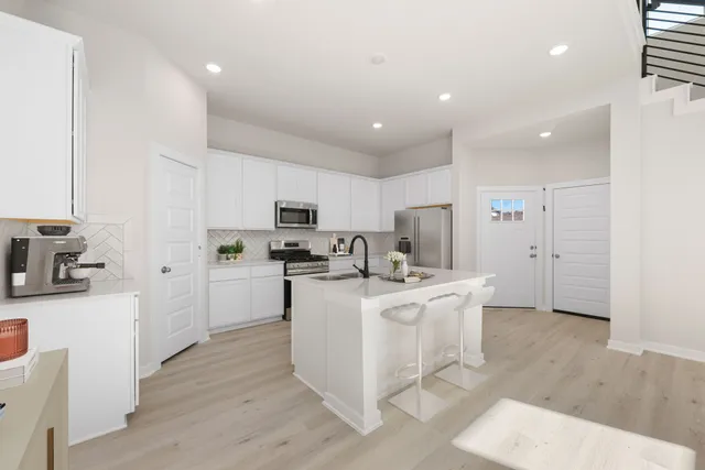 a kitchen with stainless steel appliances a stove a sink a refrigerator and cabinets