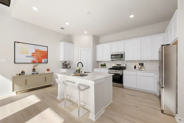 a kitchen with appliances a sink and cabinets