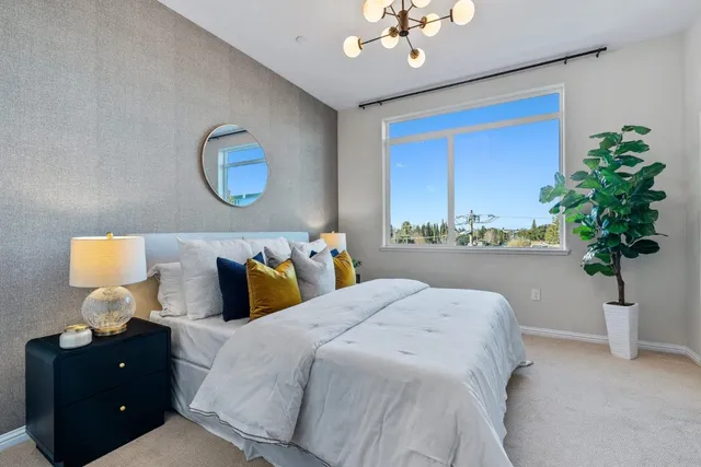 a bedroom with bed and a chandelier