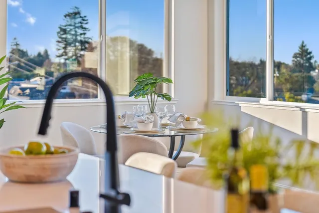 a kitchen with stainless steel appliances granite countertop a stove refrigerator a dining table and chairs with wooden floor