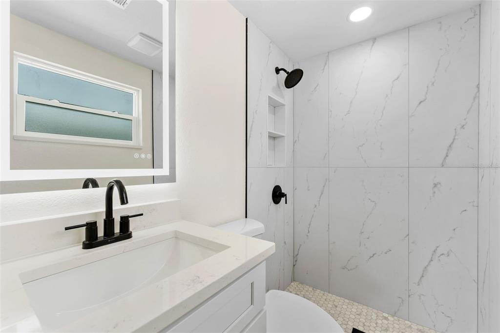 4016 Grayton Drive New Port Richey, FL 34652 - Photo 19 of 40 a bathroom with a sink toilet a shower and vanity