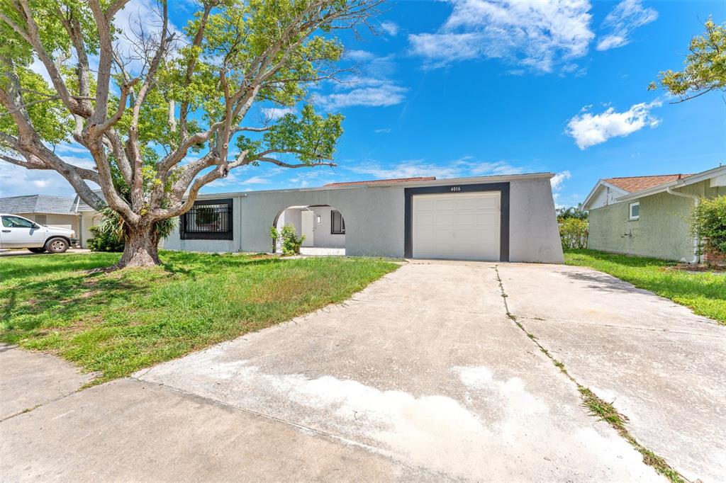4016 Grayton Drive New Port Richey, FL 34652 - Photo 2 of 40 a front view of a house with a yard and garage