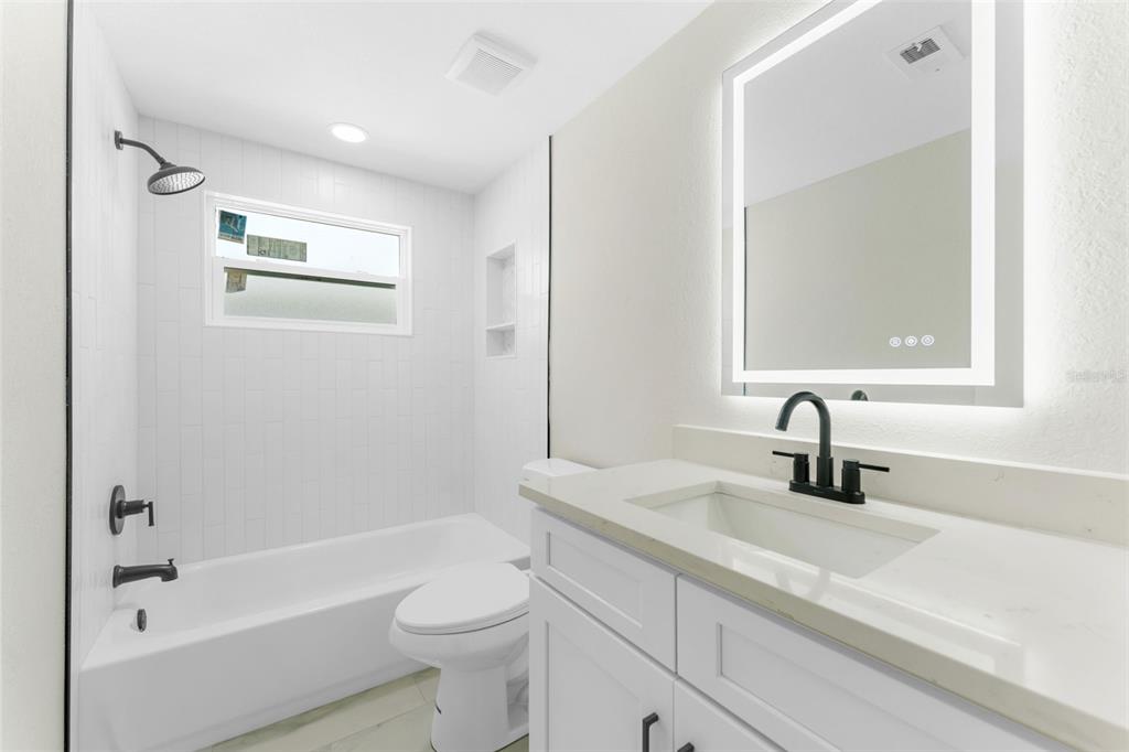 4016 Grayton Drive New Port Richey, FL 34652 - Photo 22 of 40 a bathroom with a granite countertop sink a toilet a mirror a vanity and shower