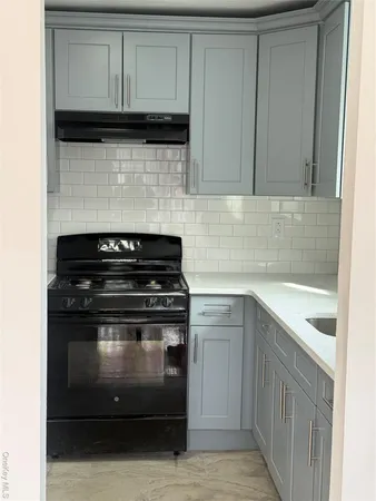 a kitchen with granite countertop white cabinets and black appliances