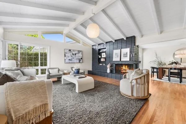 a living room with fireplace furniture and a wooden floor