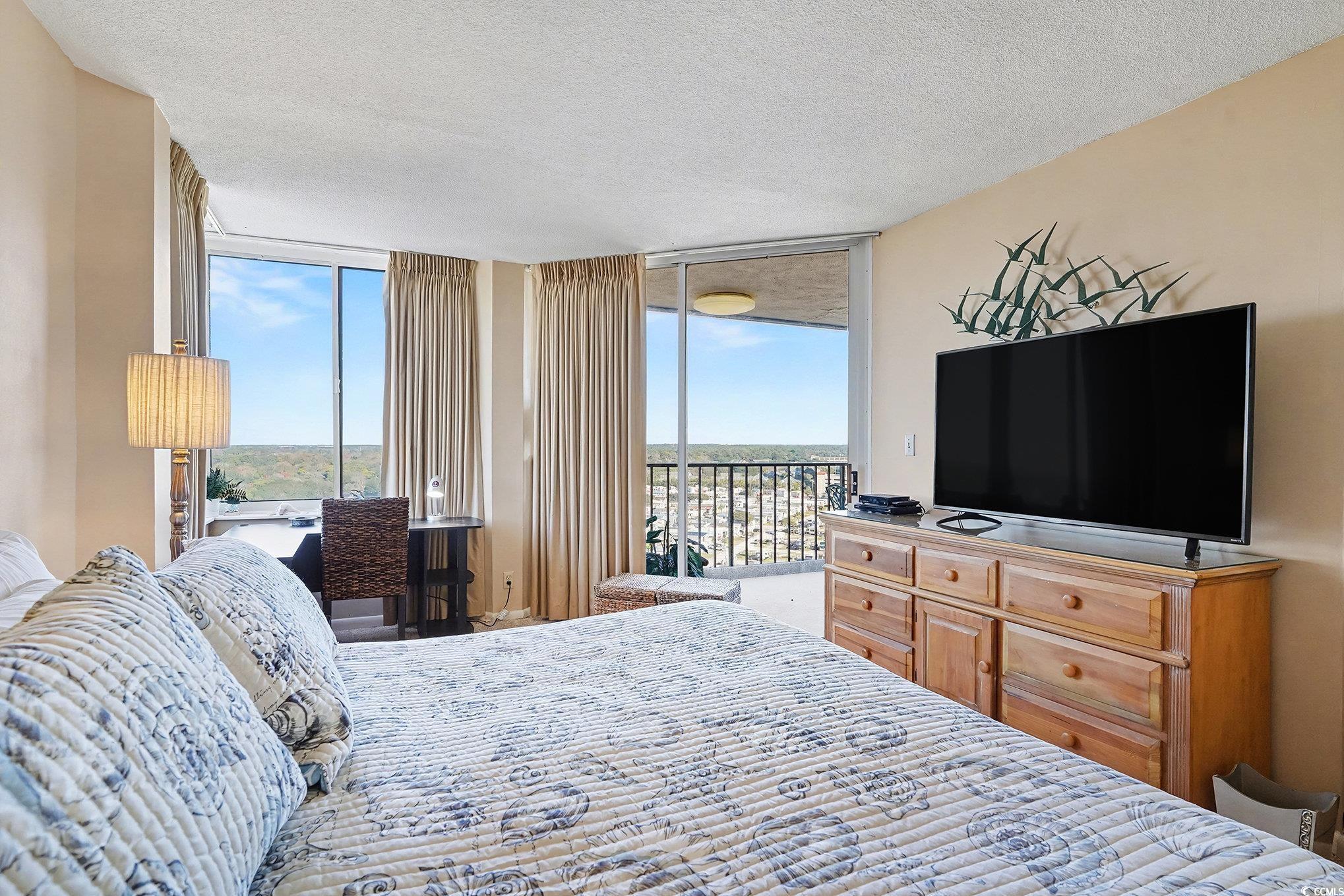 9650 Shore Drive, Unit 1507 Myrtle Beach, SC 29572 - Photo 11 of 39 Bedroom featuring a textured ceiling, floor to ceiling windows, access to outside, and multiple windows