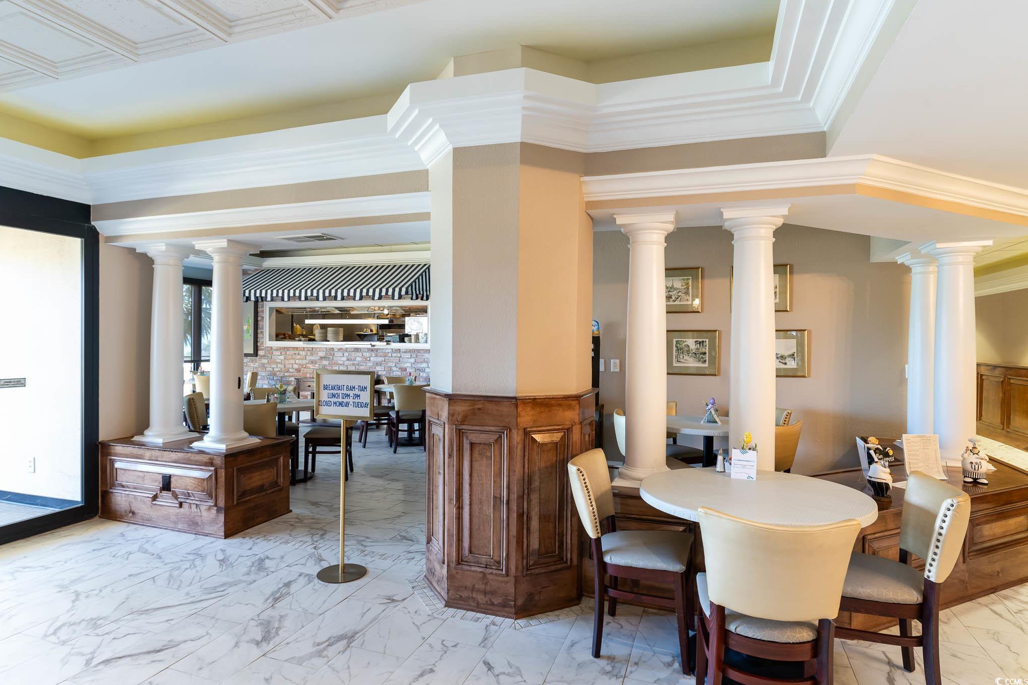 9650 Shore Drive, Unit 1507 Myrtle Beach, SC 29572 - Photo 28 of 39 Dining area with light marble finish floors, crown molding, and decorative columns