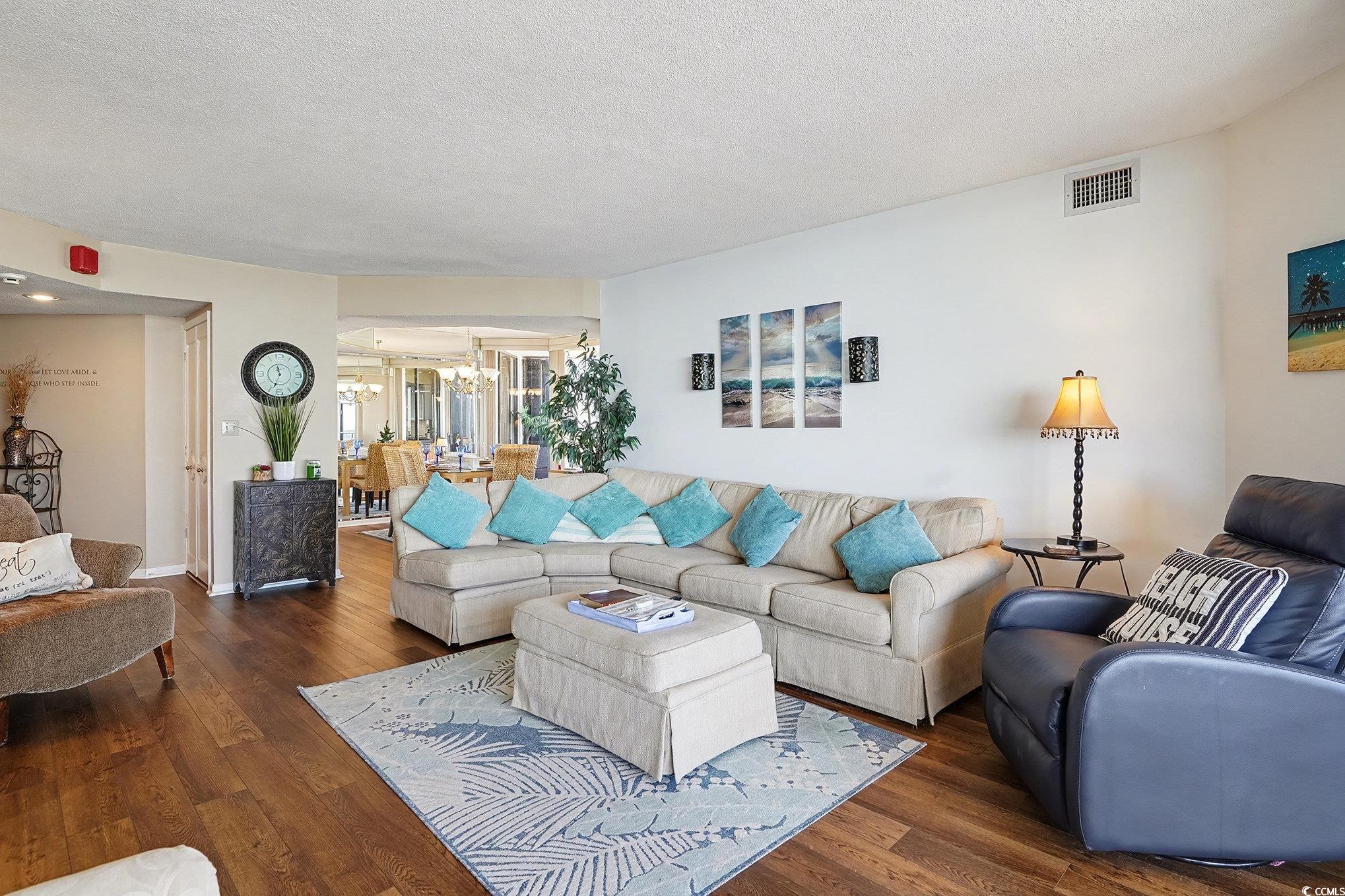9650 Shore Drive, Unit 1507 Myrtle Beach, SC 29572 - Photo 3 of 39 Living area featuring a textured ceiling, wood-type flooring, and a chandelier