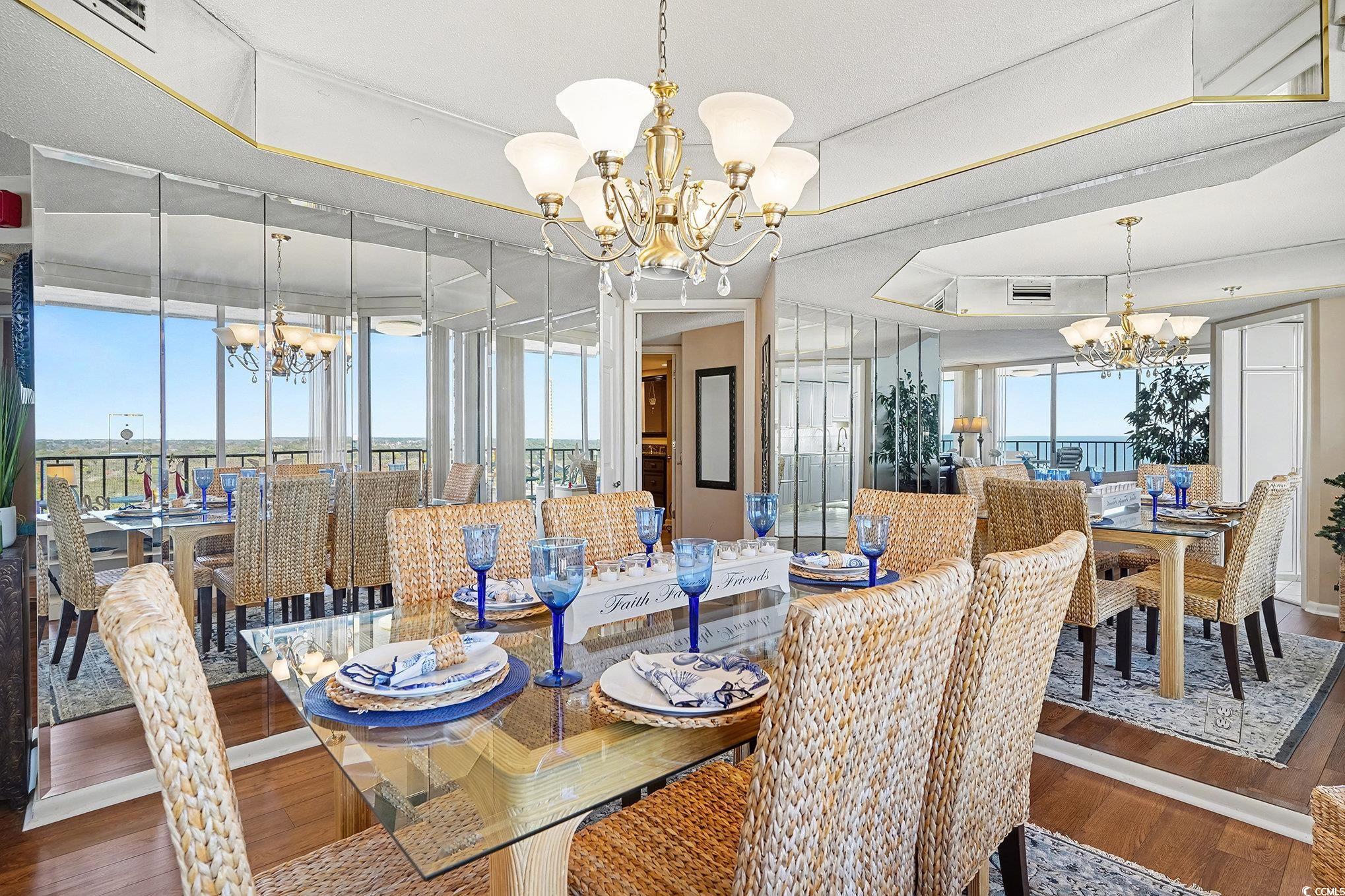 9650 Shore Drive, Unit 1507 Myrtle Beach, SC 29572 - Photo 7 of 39 Dining space featuring a chandelier, wood-type flooring, and a tray ceiling